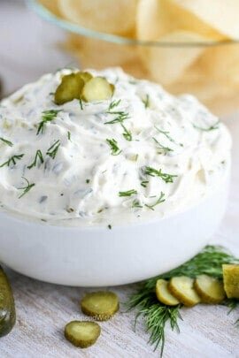 dill pickle dip in a bowl with chips on the side