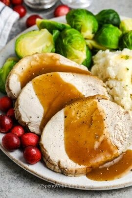 sliced turkey breast with gravy and side dishes