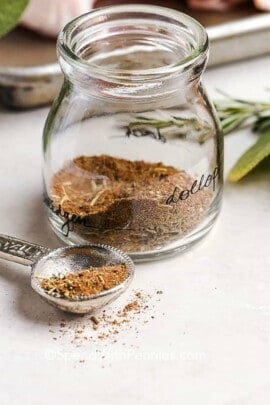 close up of turkey seasoning in a glass jar with a measuring spoon