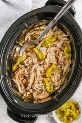 Crock Pot Mississippi Chicken in a slow cooker with a seruing spoon