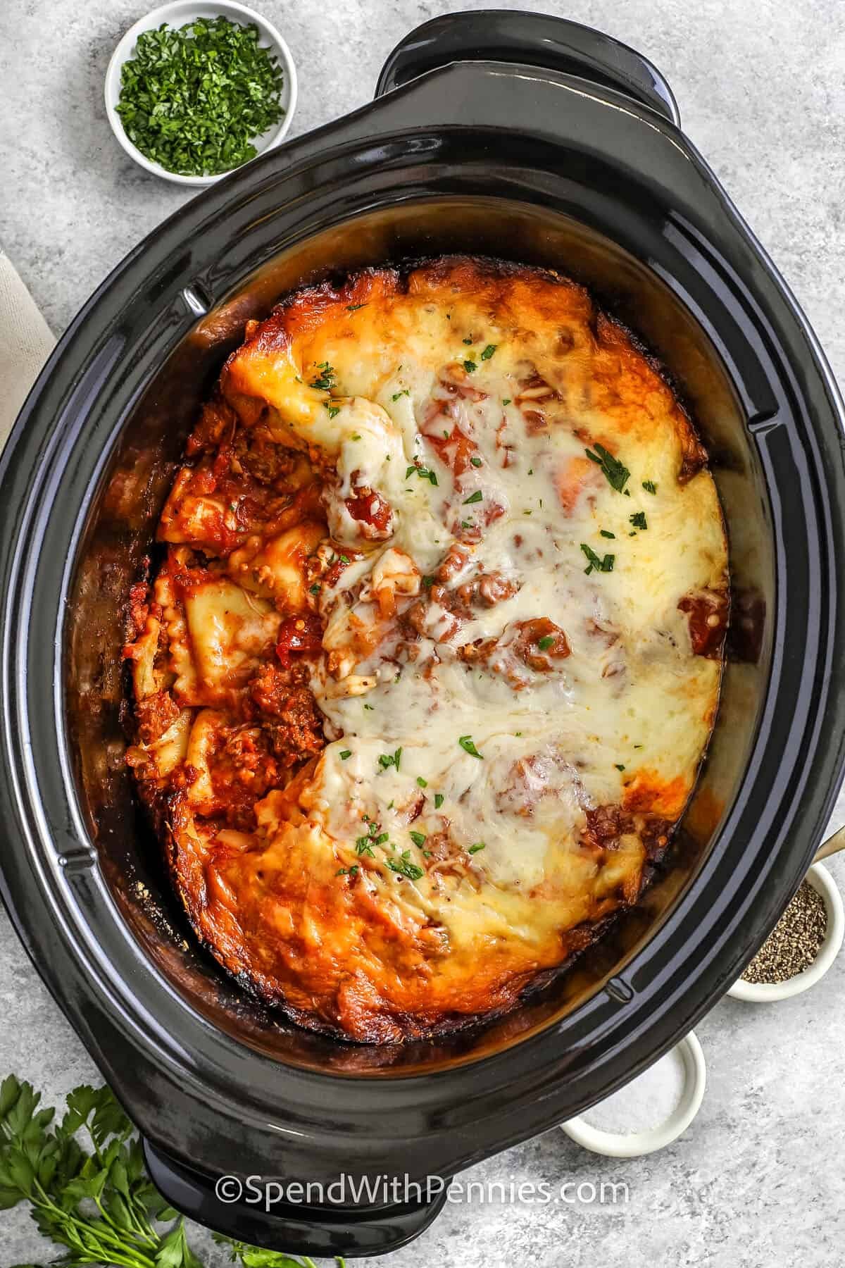 cheesy Crock Pot Lasagna with a portion taken out of the pot